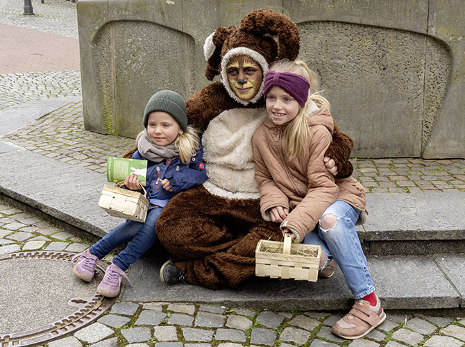 Die Osterhäsin mit Kindern auf dem Osterwochenmarkt